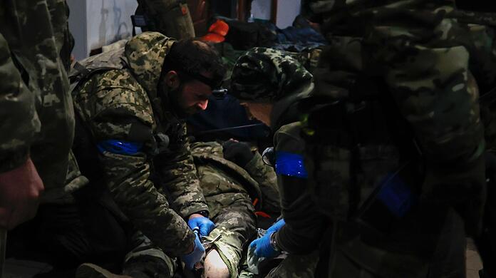 Ukrainische Soldaten leisten einem verwundeten Soldaten in einem Unterschlupf in Soldedar Erste Hilfe.