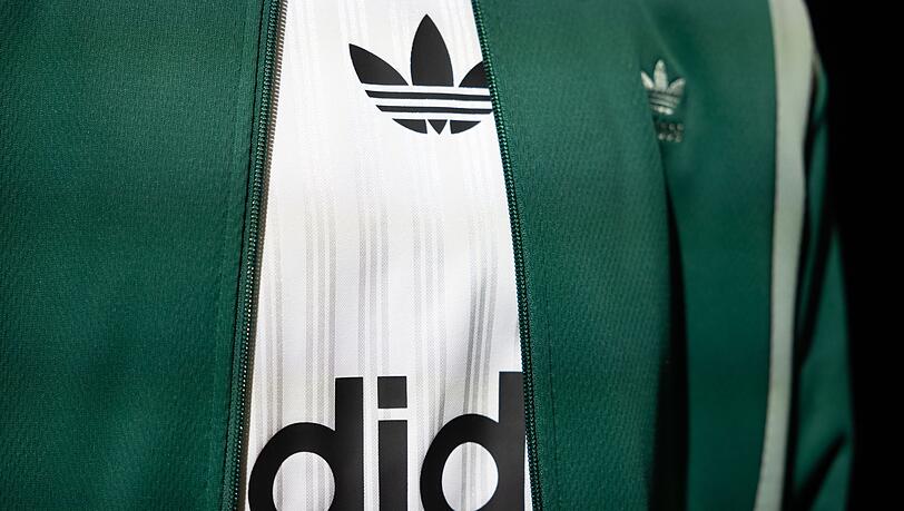 Das Logo und der Schriftzug von Adidas ist auf einem ausgestellten Kleidungsstück zu sehen.