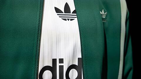 Das Logo und der Schriftzug von Adidas ist auf einem ausgestellten Kleidungsstück zu sehen.