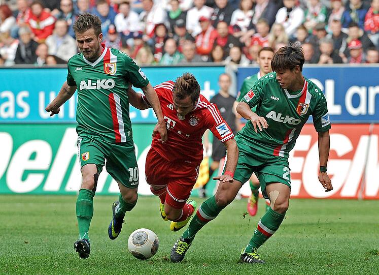 FC Augsburg - FC Bayern München am 05.04.2014 in der SGL-Arena in Augsburg. Augsburgs Daniel Baier (l) und Jeong-Ho Hong stoppen Münchens Mario Götze