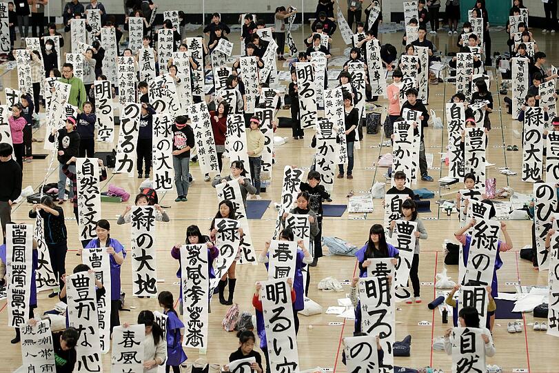 Japanische Schüler präsentieren ihre kalligraphischen Werke. Über 3000 junge Menschen nehmen jedes Jahr an dem Kalligraphiewettbewerb teil, der zur Neujahrstradition in Japan gehört. Sie zeigen dabei, wie gut sie die japanischen Schriftzeichen beherrschen.