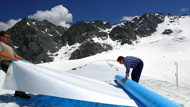 Retten, was zu retten ist: Helfer rollen im Hochsommer schützende Planen auf dem Tortin-Gletscher in der Schweiz aus. Retten, was zu retten ist: Helfer rollen im Hochsommer schützende Planen auf dem Tortin-Gletscher in der Schweiz aus.