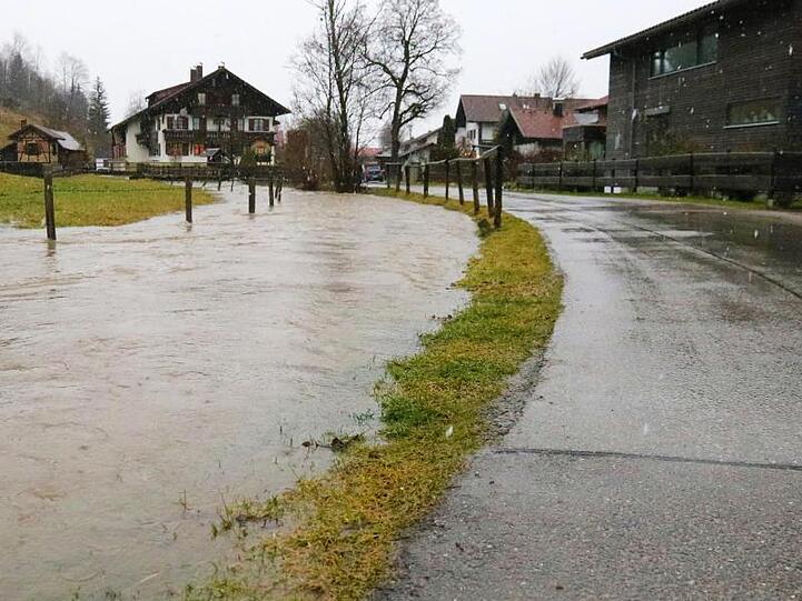 Ein Bachlauf hat sich in Fischen (Bayern) auf einer Wiese entlang einer Straße gebildet. Foto: Benjamin Liss/Archiv