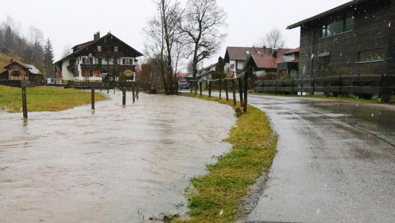 Ein Bachlauf hat sich in Fischen (Bayern) auf einer Wiese entlang einer Straße gebildet. Foto: Benjamin Liss/Archiv