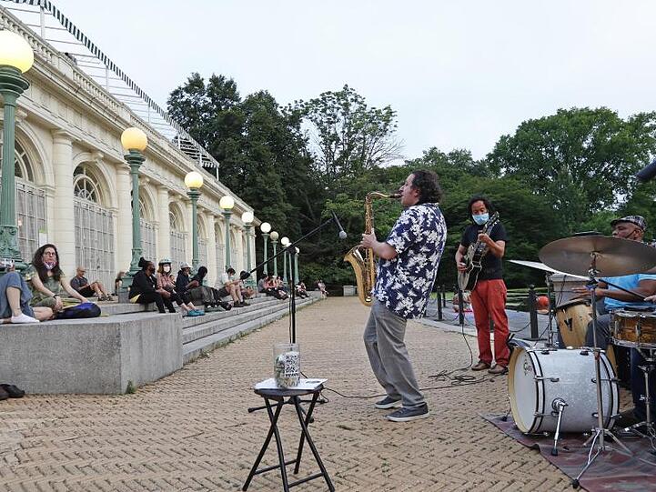 Musiker spielen an den Stufen von Brooklyns Wahrzeichen, dem Bootshaus Prospect Park.