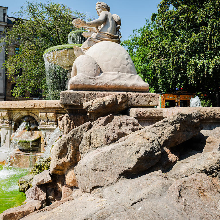 Hier am Wittelsbacher Brunnen hat sich seit einigen Jahren ein kleiner Pumuckl aus Bronze versteckt. K&ouml;nnen Sie ihn entdecken?