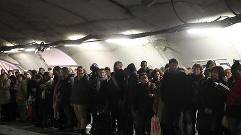 Pendler warten an einem Bahnsteig in Paris vergeblich auf eine U-Bahn.