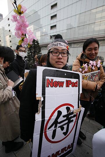 Nein, das ist keine Demonstration für Menschenrechte. Der junge Mann freut sich nur in Tokio auf das neue iPad. Auf seinem Schild steht: Samurai-Krieger.