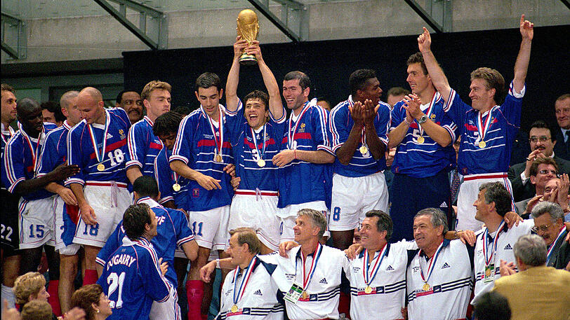 1998: Die französische Nationalmannschaft ist Weltmeister geworden. Bayern-Spieler Bixente Lizarazu reckt den Pokal in die Höhe.