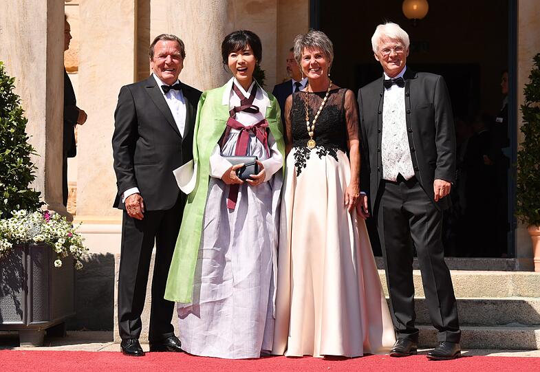 Die Bayreuther Oberbürgermeisterin Brigitte Merk-Erbe (2.v.r.) und ihr Mann Thomas (r) begrüßen zum Beginn der Bayreuther Festspiele 2019 Altbundeskanzler Gerhard Schröder (SPD) undd dessen Frau Soyeon Kim.