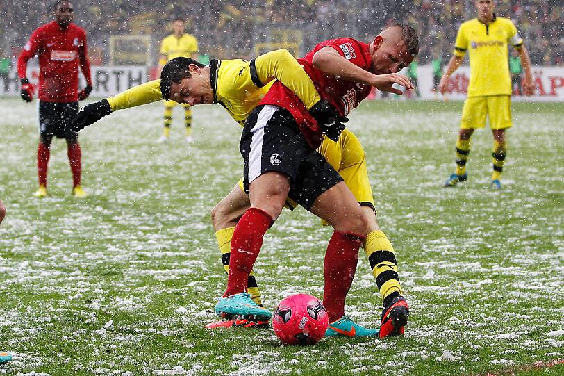 Die Bilder aus Freiburg. Die Linien müssen freigeräumt werden, der Ball ist rot und Spieler wie Trainer sind nicht zu beneiden. Doch dennoch wird gespielt.