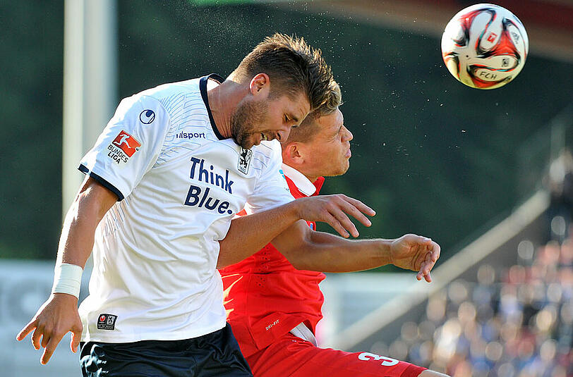 Heidenheims Florian Niederlechner (r) und Münchens Markus Steinhöfer kämpfen um den Ball.