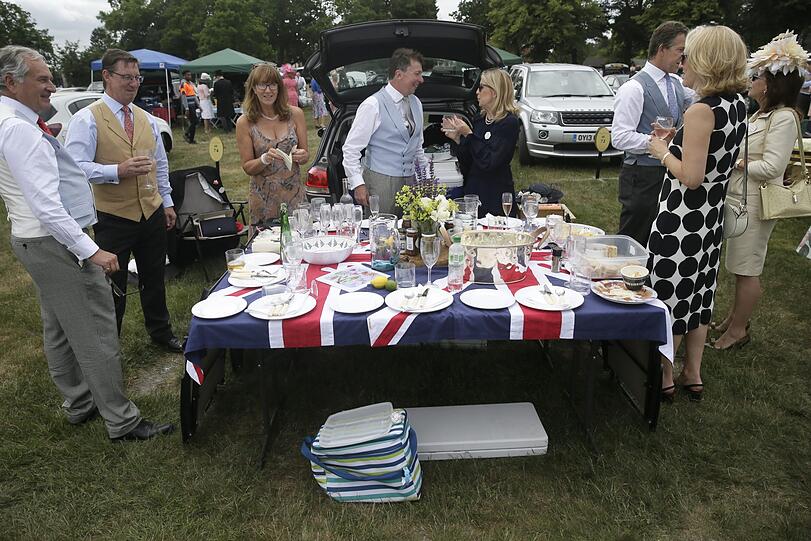 Camping Deluxe: Gäste stehen an der Ascot Rennstrecke um einen Tisch mit Essen und Trinken