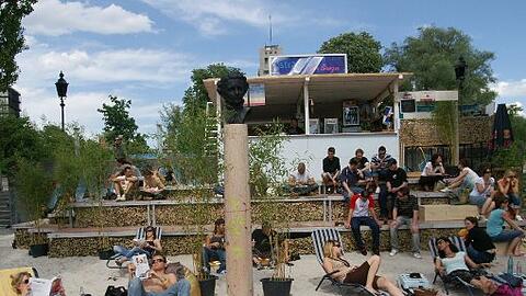 Der Kulturstrand der Urbanauten auf dem Isarbalkon mitten auf der Corneliusbrücke. Auf der Stele ist ein Abguss des Kini-Kopfs. Das nächste Foto zeigt den Plan für den Isarzugang.
