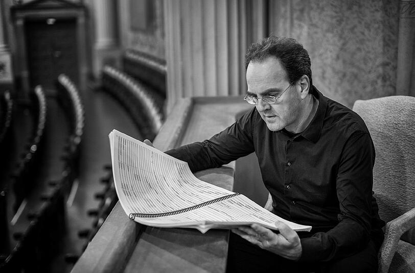Der Dirigent Joachim Tschiedel studiert eine Partitur.