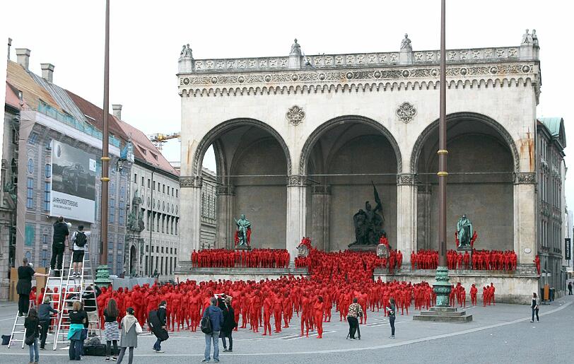 Star-Fotograf Spencer Tunick lässt zur Eröffnung der Opernfestspiele für seine Installation hunderte bunt angemalte Menschen durch München laufen. Das Highlight: Die rot-goldenen Teilnehmer stellen sich an Münchner Monumenten entlang der Ludwigstraße auf. Hier gibts die Bilder!