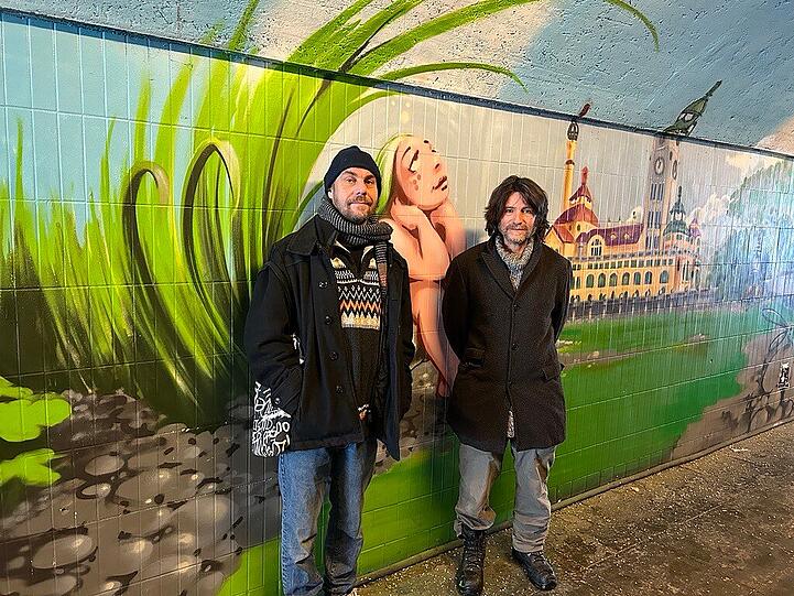 Flin und Loomit am gesprayten Müller'schen Volksbad. Zwischen den beiden: Die melancholisch grübelnde Statue vom Süd-Eingang des Tunnels, neu interpretiert von Flin.