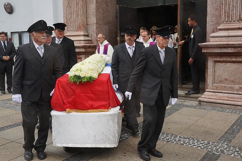 Der mit Rosen geschmückte Sarg von Pierre Brice wird aus der St. Michael Kirche herausgetragen