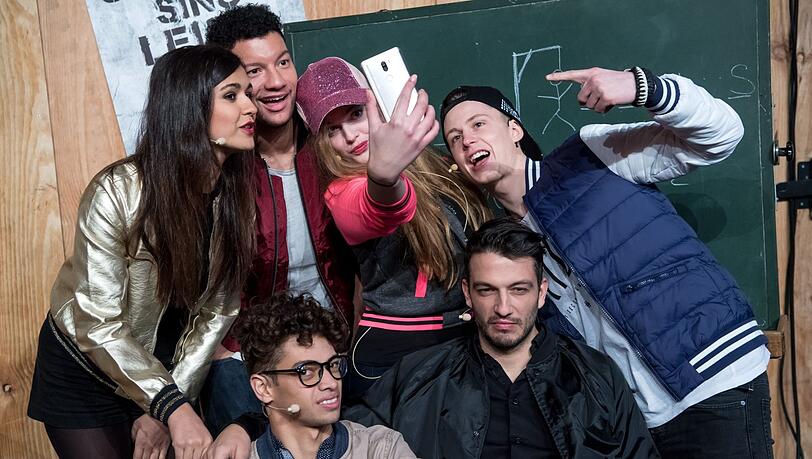 Die Darsteller des Musicals „Fack ju Göhte – Se Mjusicäl“ Susanne Studentkowski (als Zeynep, hinten, v.l.n.r.), Anthony Kirby (als Burak), Rebekka Corcodel (als Chantal), Lukas Sandmann (als Danger), Robin Cadet (als Jerome, vorne l.) und Max Hemmersdorfer (als Zeki Müller). Die Darsteller des Musicals „Fack ju Göhte – Se Mjusicäl“ Susanne Studentkowski (als Zeynep, hinten, v.l.n.r.), Anthony Kirby (als Burak), Rebekka Corcodel (als Chantal), Lukas Sandmann (als Danger), Robin Cadet (als Jerome, vorne l.) und Max Hemmersdorfer (als Zeki Müller).
