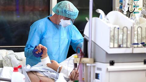 Ein Facharzt versorgt einen Covid-19-Patienten auf der Intensivstation der Leipziger Uniklinik.
