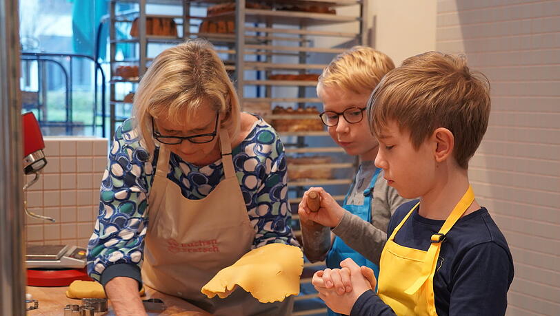Wunschkinder der "Aktion Kindertraum" und eine Oma von Kuchentratsch backen gemeinsam Platzerl. Aktion Kindertraum