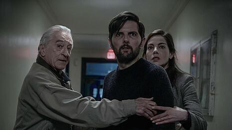 Kann etwas sein, das eigentlich nicht sein kann? In der Thriller-Bestseller-Verfilmung "Der Kinderfl&uuml;sterer" scheint ein Serienkiller zur&uuml;ckgekehrt, der eigentlich in Haft sitzt. Der Sohn von Tom Kennedy (Adam Scott, zweiter von links) ist verschwunden. Toms Vater und Ex-Ermittler (Robert De Niro) sowie die neue Ermittlerin (Michelle Monaghan) halten ihn zur&uuml;ck.