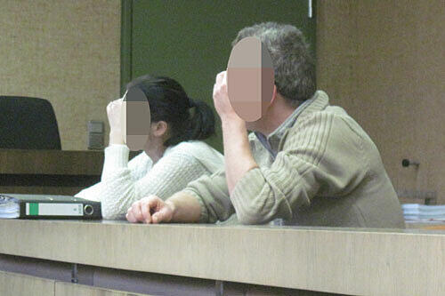 Corinna B. (l.) und Wilfried K. verbergen ihre Gesichter, als sie auf der Anklagebank des Landgerichts Platz nehmen.
