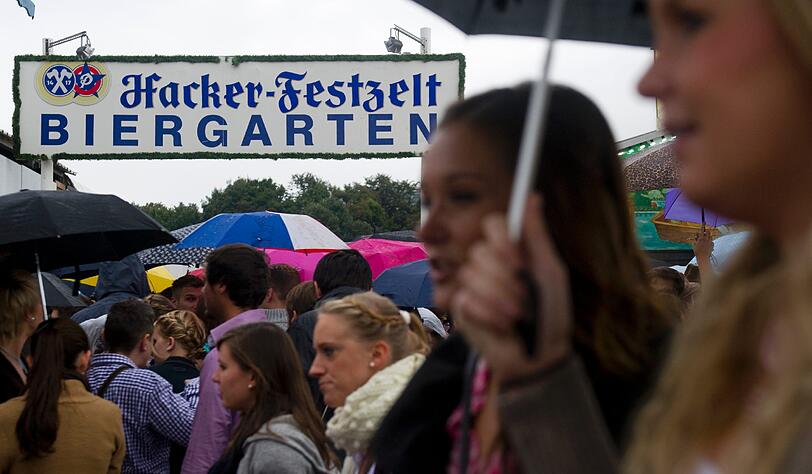 Trotz Sauwetter und Regen warten bereits viele Wiesngänger auf den Wiesnanstich. Der Kampf um den Platz im Bierzelt beginnt schon am frühen Morgen. Die ersten Bilder.