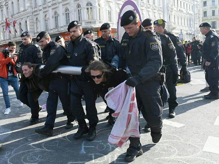 Aktivisten werden in Wien von Polizisten weggetragen.
