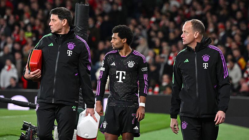 Münchens Serge Gnabry (M) geht mit der medizinischer Betreuung nach seiner Auswechslung vom Feld.