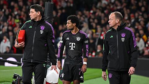 Münchens Serge Gnabry (M) geht mit der medizinischer Betreuung nach seiner Auswechslung vom Feld.