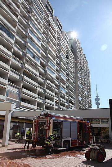 Ein Einsatzfahrzeug der Feuerwehr vor dem Hochhaus im Olympiadorf.