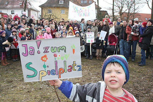 Miro ist vier Jahre alt, er wünscht sich eine Ecke auf der Wiese mit Schaukel, Wippe und Rutsche. Sie soll dort entstehen, wo im Hintergrund die Spielplatz-Befürworter demonstrieren.