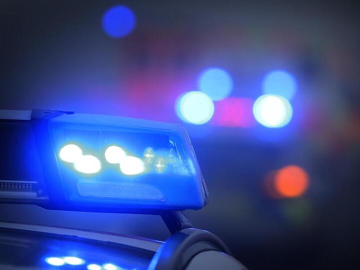 Ein Polizeiauto inn Bayern mit eingeschaltetem Blaulicht.