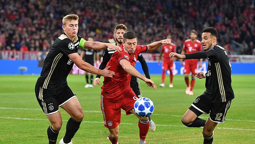 Spielten früher bei Ajax Amsterdam zusammen – und bald schon beim FC Bayern? Matthijs de Ligt (l.) und Noussair Mazraoui (r.), hier im Zweikampf mit Bayerns Robert Lewandowski.