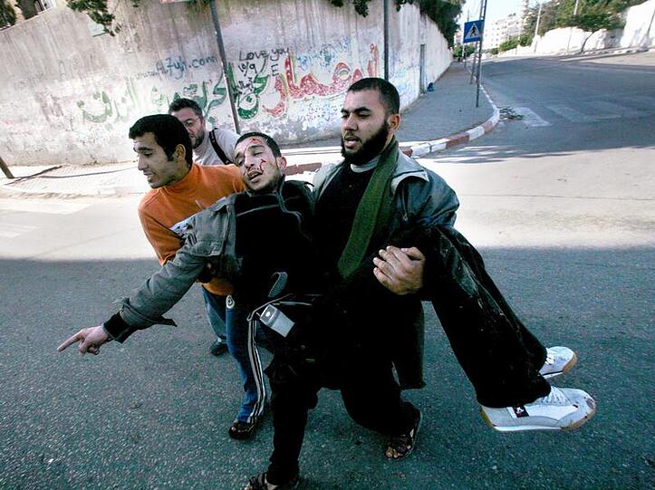 Palästinenser tragen ein durch israelischen Beschuss verletztes Hamas-Mitglied.