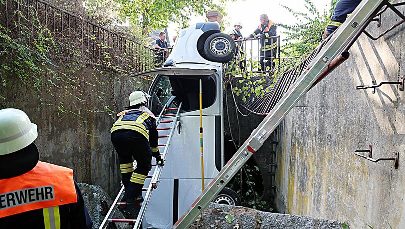 Ein Transporter durchbricht ein Metallgeländer und landet senkrecht im Bach. Ein Transporter durchbricht ein Metallgeländer und landet senkrecht im Bach.