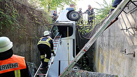 Ein Transporter durchbricht ein Metallgel&auml;nder und landet senkrecht im Bach.