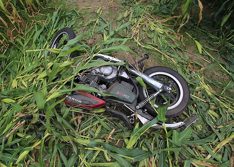 Beim Versuch dem entgegenkommenden Auto auszuweichen, touchierte der Motorradfahrer das Auto, stürzte in ein Maisfeld und verletzte sich schwer.