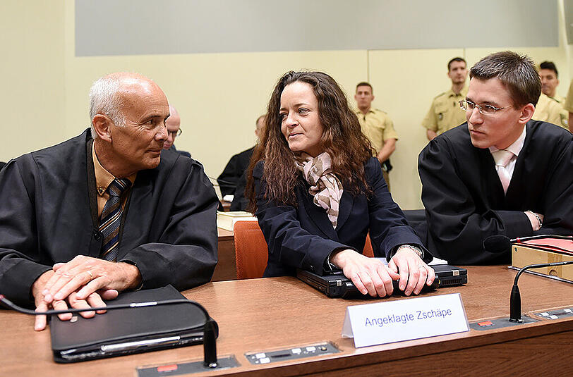 Die Angeklagte Beate Zschäpe mit ihren Anwälten Hermann Borchert (l) und Mathias Grasel (r) am 09.12.2015 im Gerichtssaal im Oberlandesgericht.