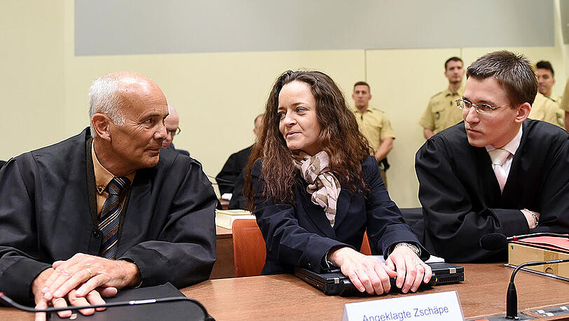 Die Angeklagte Beate Zschäpe mit ihren Anwälten Hermann Borchert (l) und Mathias Grasel (r) am 09.12.2015 im Gerichtssaal im Oberlandesgericht.