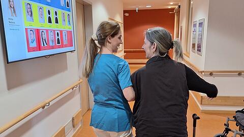 Pflegefachkraft Anela Bacevac begleitet und stützt Bewohnerin Andrea Maskalidis (60) bei ihrem Rundgang durch den neurologischen Bereich im Haus an der Effnerstraße. Foto: Maximilian Neumair
