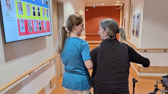 Pflegefachkraft Anela Bacevac begleitet und stützt Bewohnerin Andrea Maskalidis (60) bei ihrem Rundgang durch den neurologischen Bereich im Haus an der Effnerstraße. Foto: Maximilian Neumair