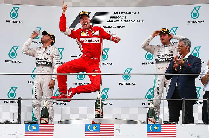 Sebastian Vettel macht einen Luftsprung auf dem Podium: Er hat in Sepang sein erstes Formel-1-Rennen im Ferrari gewonnen.