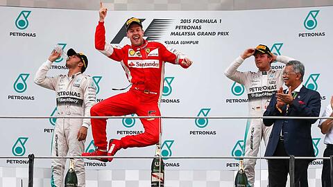 Sebastian Vettel macht einen Luftsprung auf dem Podium: Er hat in Sepang sein erstes Formel-1-Rennen im Ferrari gewonnen.