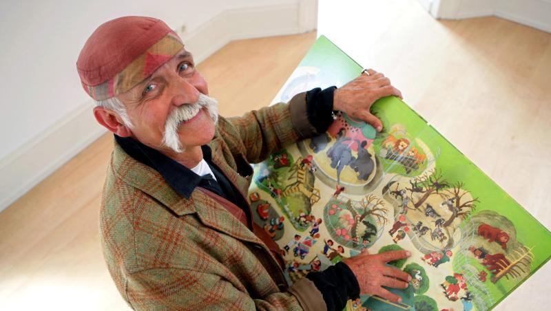 Ali Mitgutsch hält im Bilderbuchmuseum eines seiner Kinderbücher in den Händen. Foto: Rolf Vennenbernd/dpa/Archivbild Ali Mitgutsch hält im Bilderbuchmuseum eines seiner Kinderbücher in den Händen. Foto: Rolf Vennenbernd/dpa/Archivbild