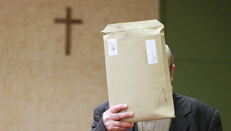 Der Angeklagte steht am 11.03.2014 in München im Sitzungssaal und verdeckt seinen Kopf mit einem Briefumschlag. Der Mann muß sich wegen Vergewaltigung einer 14-Jährigen auf dem Friedhof von Herrsching verantworten. Der Angeklagte steht am 11.03.2014 in München im Sitzungssaal und verdeckt seinen Kopf mit einem Briefumschlag. Der Mann muß sich wegen Vergewaltigung einer 14-Jährigen auf dem Friedhof von Herrsching verantworten.