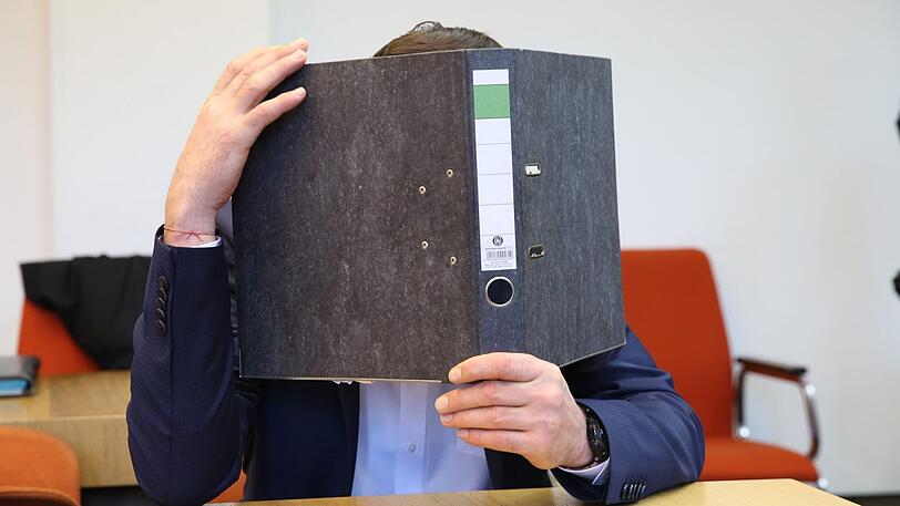 Der Angeklagte verbirgt vor Gericht sein Gesicht.