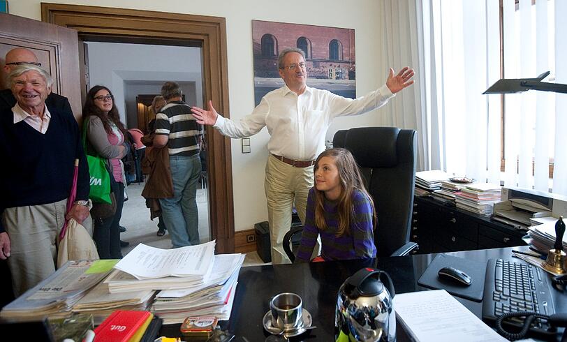 Münchens Oberbürgermeister Christian Ude (r.) begrüßt während des Tags der offenen Tür im Rathaus in München Besucher in seinem Büro.