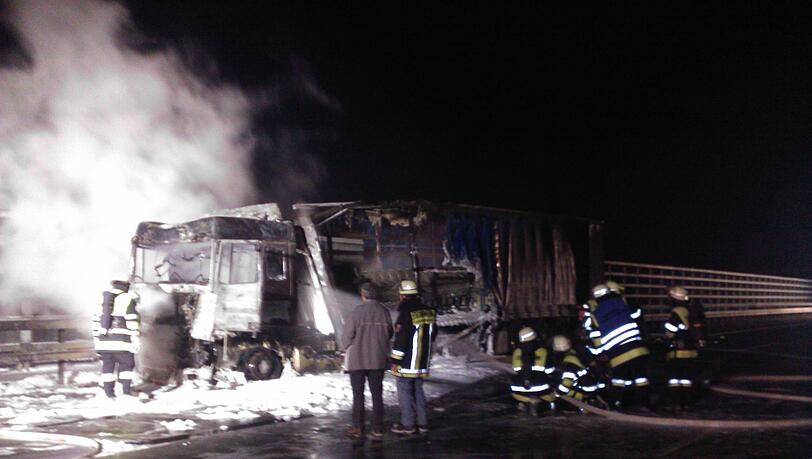 Im Hintergrund beleuchten die Scheinwerfer der Feuerwehr gespenstisch den Qualm, der aus dem ausgebrannten Lkw steigt. Im Hintergrund beleuchten die Scheinwerfer der Feuerwehr gespenstisch den Qualm, der aus dem ausgebrannten Lkw steigt.